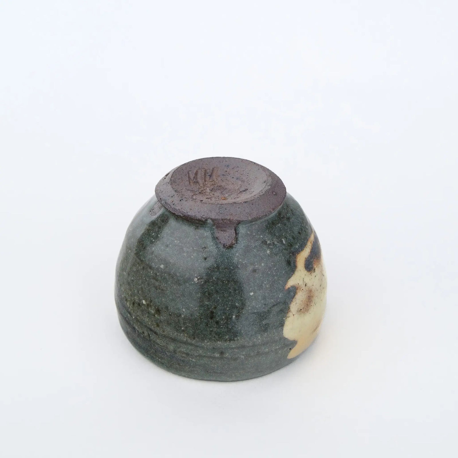 Ceramic cup with a unique glaze pattern on a white background - underside view