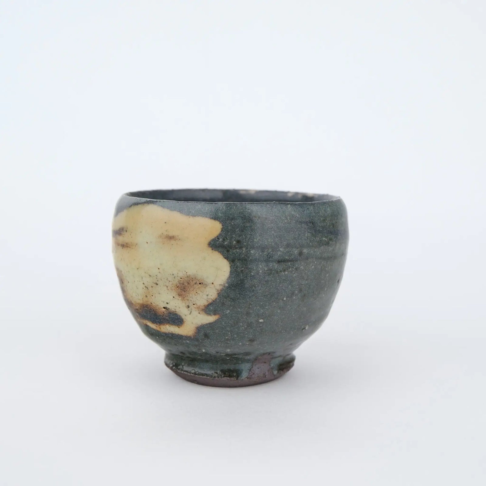 Ceramic cup with a unique glaze pattern on a white background