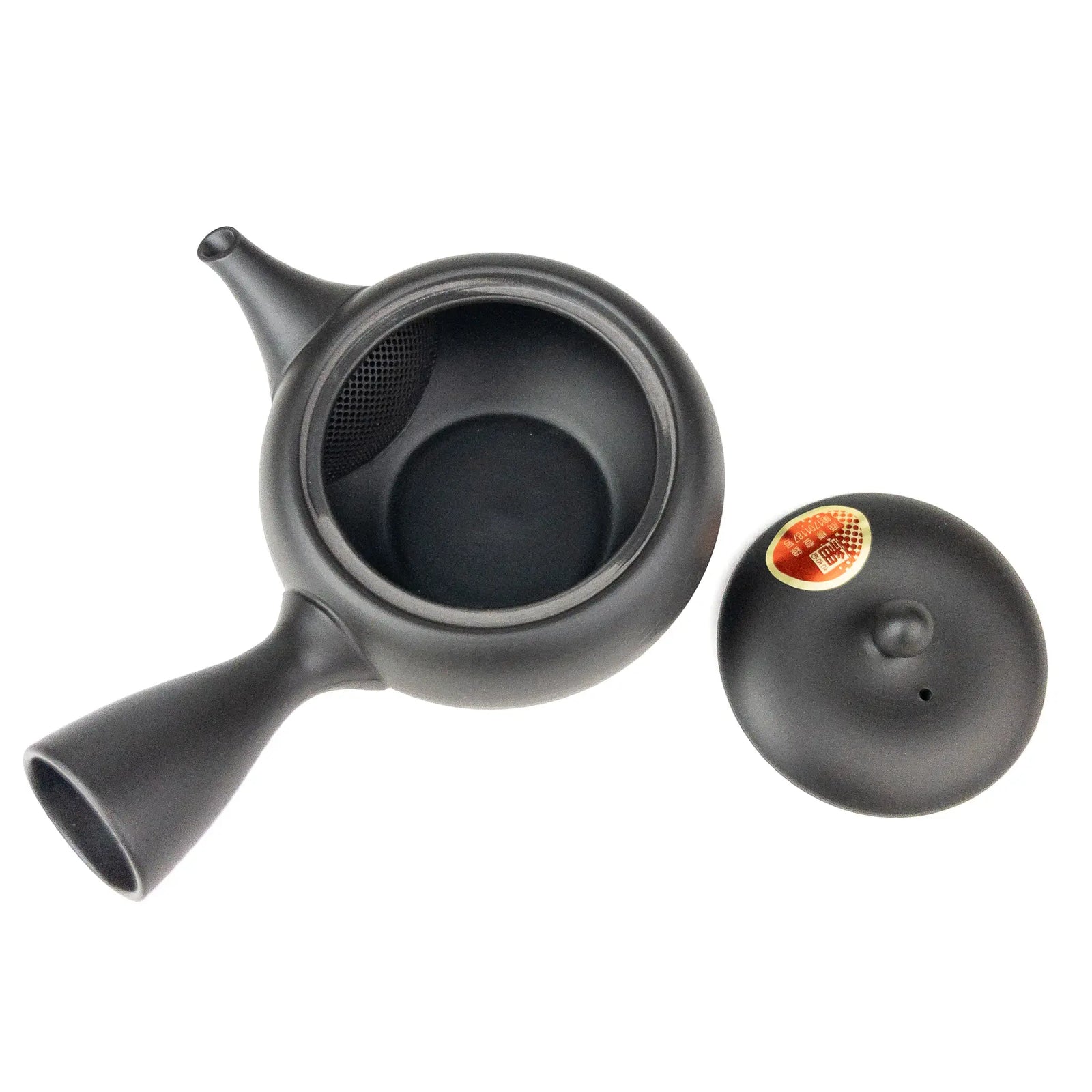 Black ceramic teapot with lid beside it on a white background
