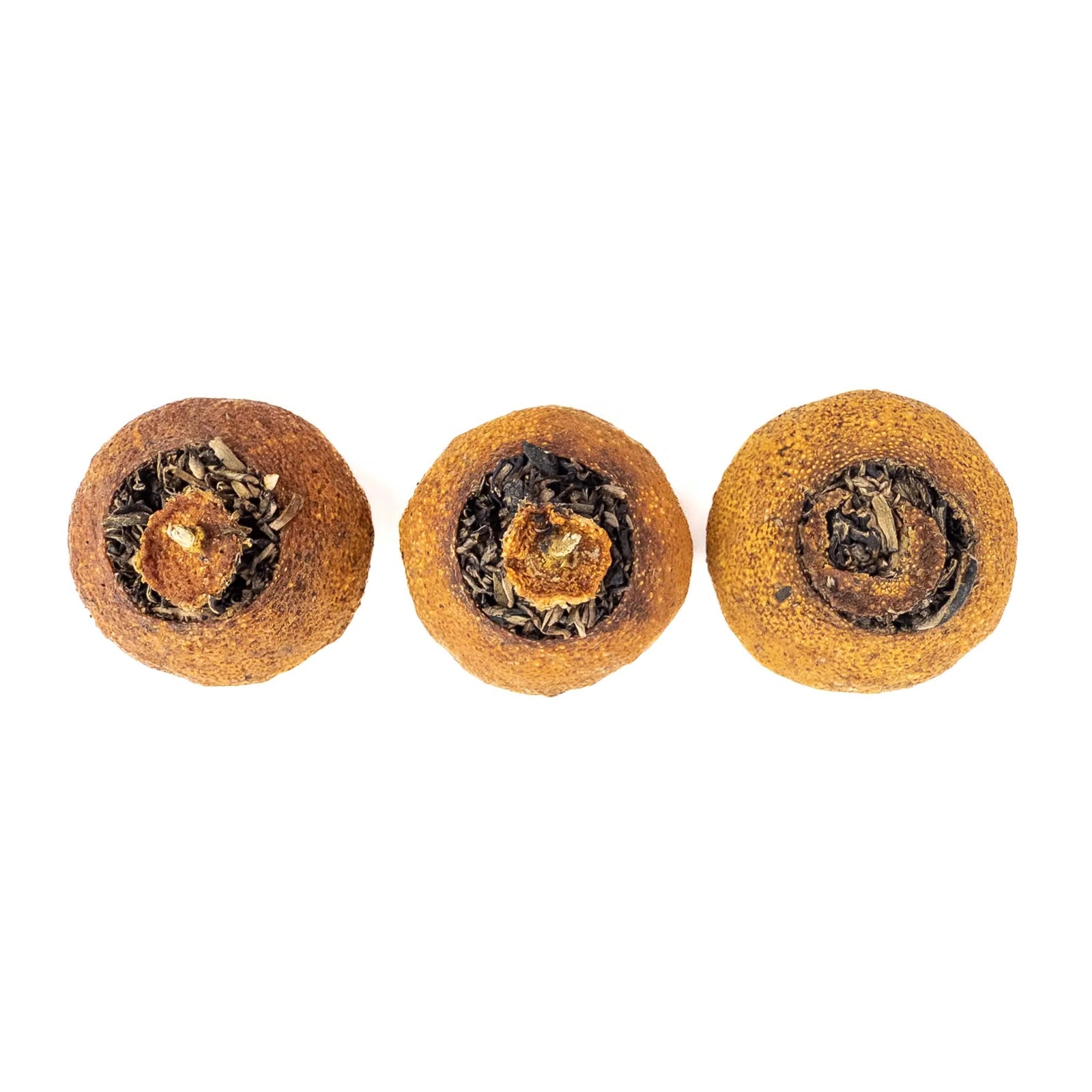 Three round tangerines with tea inside on a white background