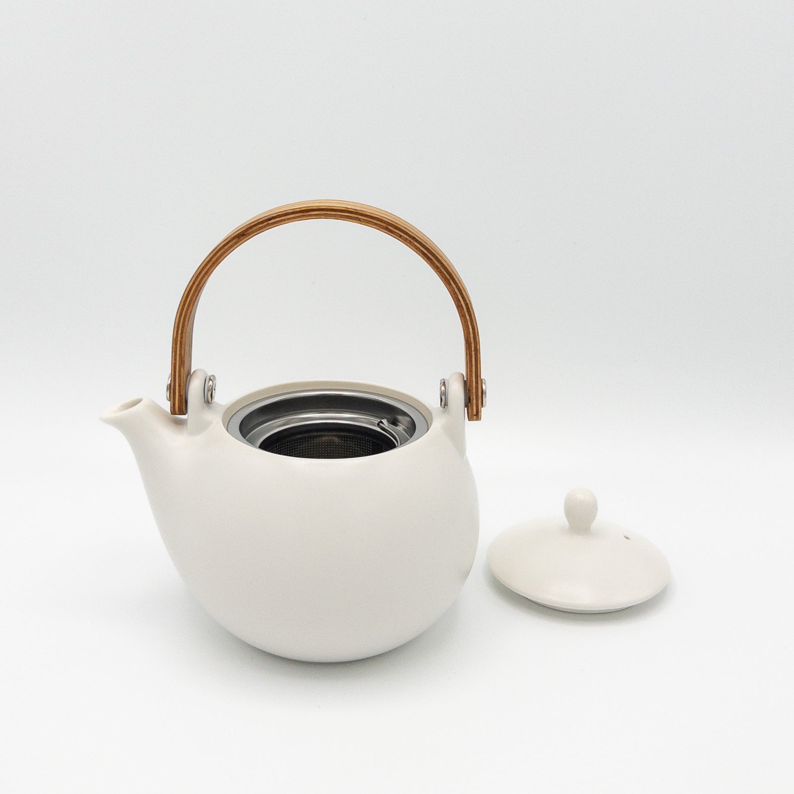 White ceramic teapot with wooden handle on a white background