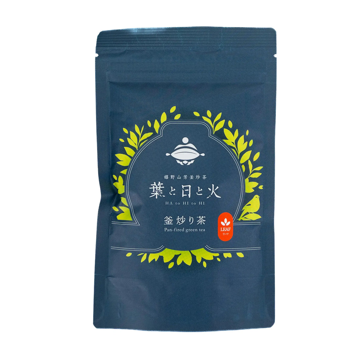Ha to Hi to Hi Ureshino kamairicha 50 gram bag, front, dark navy stand-up pouch with a wreath of green leaves, a small bird, and Ha to Hi to Hi and Pan-fired green tea printed on the label