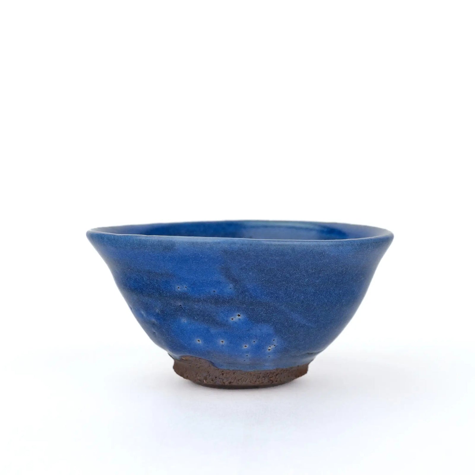 Mark Mohler gong fu cup #2Q, about 50 ml, side view of the flared cup in a deep blue glaze with small pinholes and an unglazed brown foot
