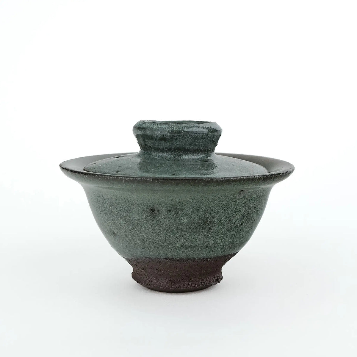 Mark Mohler handmade gaiwan #8 at eye level with the lid on, speckled green glaze ending above the dark unglazed foot